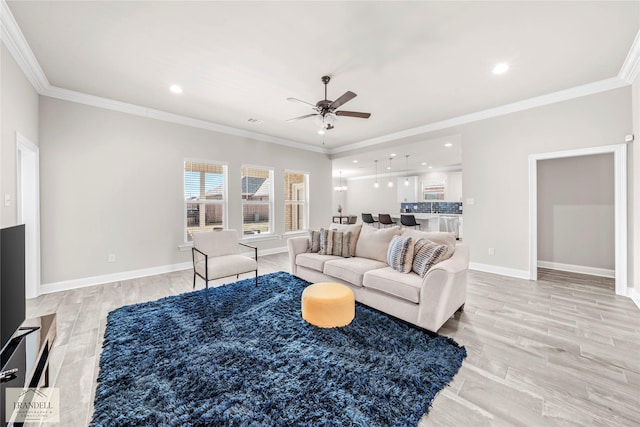 living room with crown molding, ceiling fan, and light hardwood / wood-style flooring