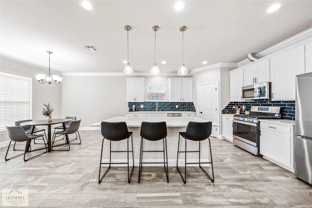 kitchen with white cabinetry, stainless steel appliances, a kitchen island, and hanging light fixtures