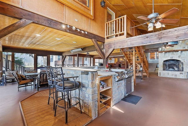 interior space featuring vaulted ceiling, appliances with stainless steel finishes, a fireplace, wood walls, and ceiling fan