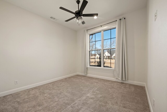 carpeted spare room with ceiling fan