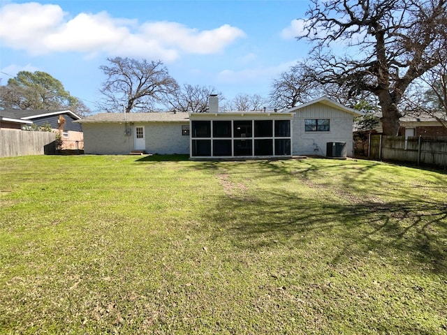 back of house with cooling unit, a yard, and a sunroom