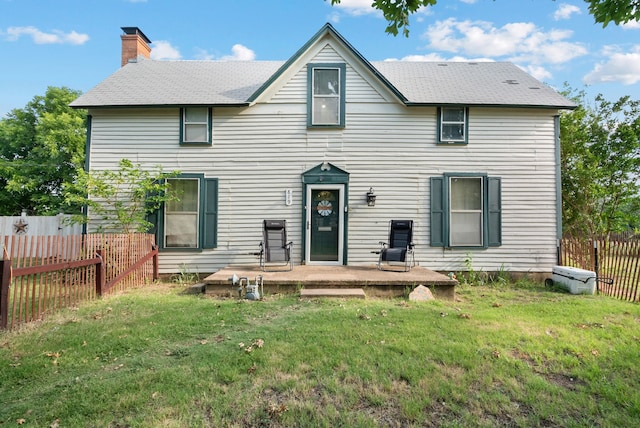 rear view of property featuring a lawn