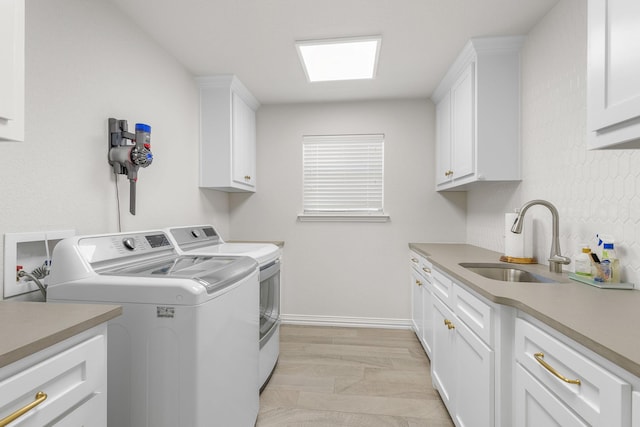 laundry room featuring sink, washer and clothes dryer, and cabinets