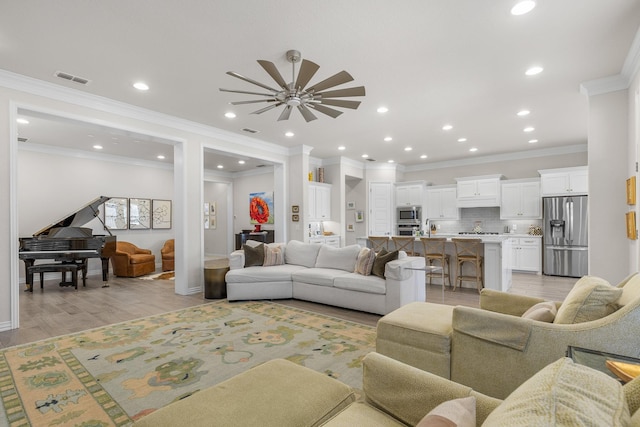 living room featuring crown molding and light hardwood / wood-style flooring