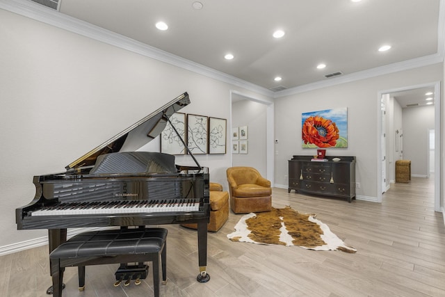 sitting room featuring ornamental molding and light wood-type flooring