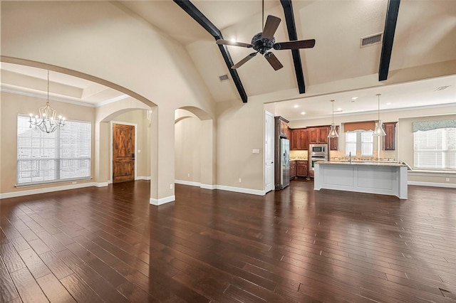 unfurnished living room with beam ceiling, ceiling fan with notable chandelier, high vaulted ceiling, and dark hardwood / wood-style floors