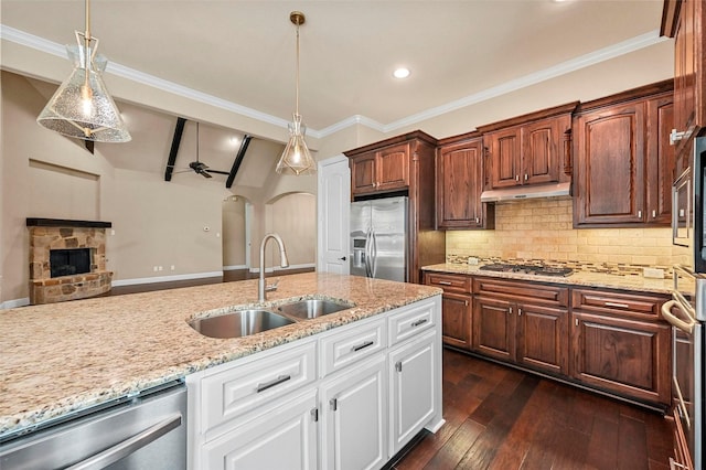 kitchen featuring appliances with stainless steel finishes, sink, pendant lighting, and white cabinets