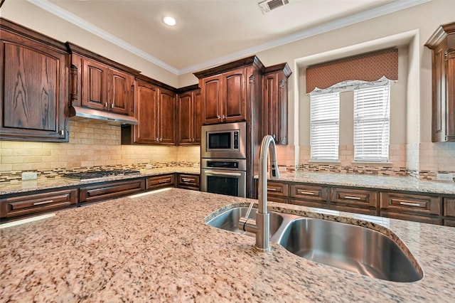 kitchen featuring light stone counters, sink, and stainless steel appliances