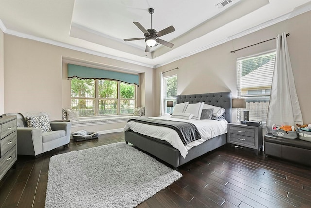 bedroom featuring dark hardwood / wood-style flooring, crown molding, a raised ceiling, and ceiling fan