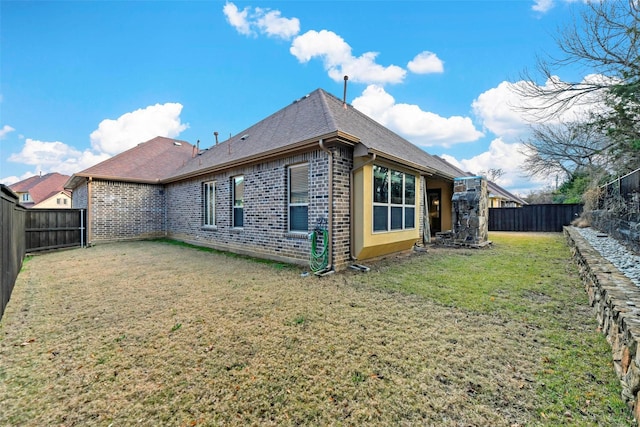 rear view of house featuring a yard