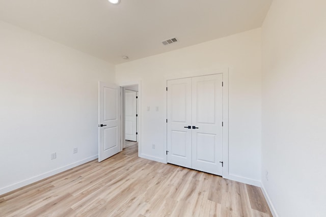 unfurnished bedroom with a closet and light hardwood / wood-style flooring