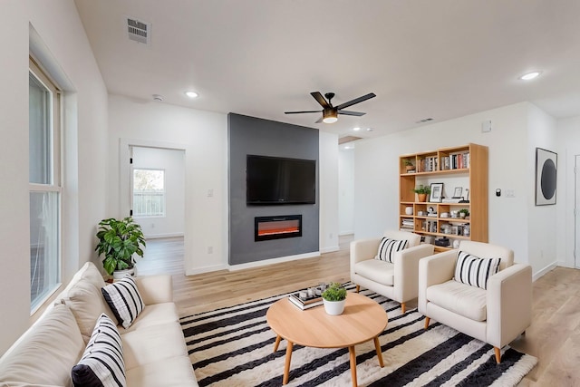 living room with light hardwood / wood-style floors and ceiling fan