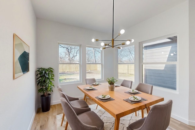 dining space featuring a notable chandelier and light wood-type flooring