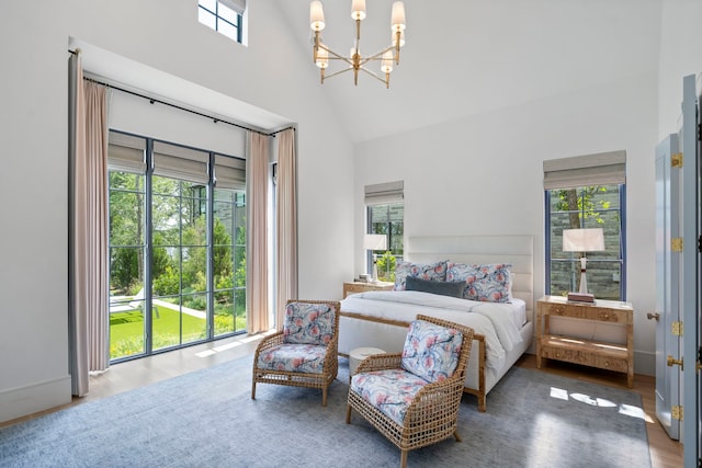 bedroom with a high ceiling, hardwood / wood-style floors, and a notable chandelier