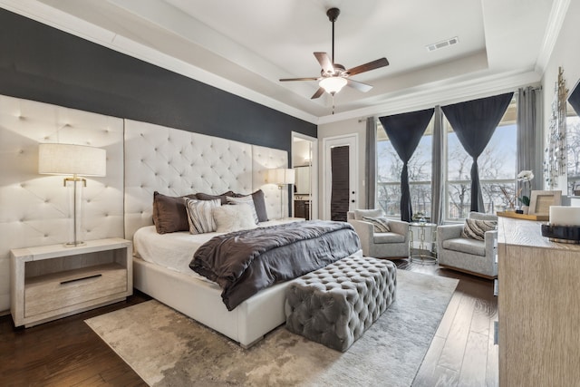 bedroom featuring a raised ceiling, ornamental molding, dark hardwood / wood-style floors, and access to outside