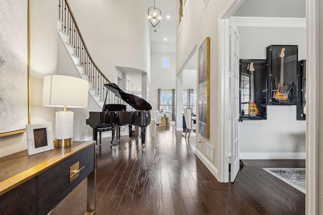 entryway with dark wood-type flooring and a towering ceiling