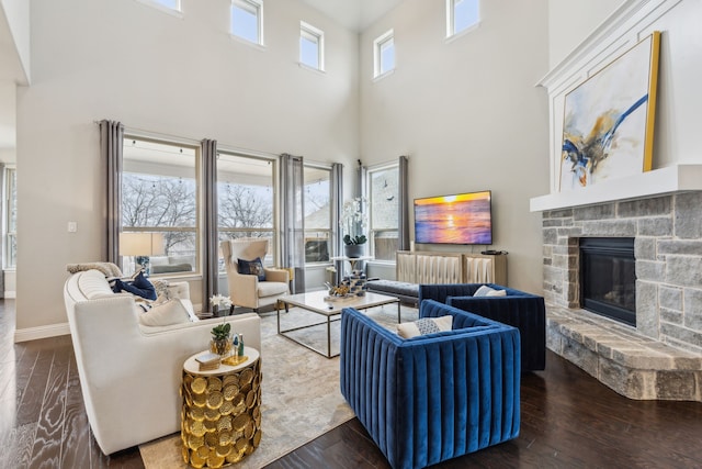 living room featuring dark hardwood / wood-style flooring and a stone fireplace