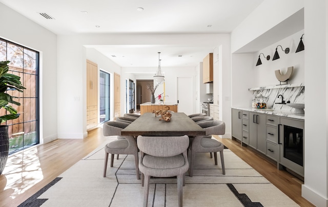 dining room with visible vents, light wood-style flooring, and baseboards