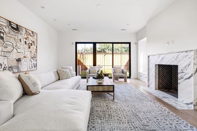 living room featuring light wood-style flooring, a fireplace, and visible vents