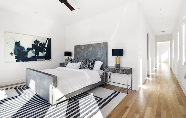 bedroom featuring ceiling fan, baseboards, and wood finished floors