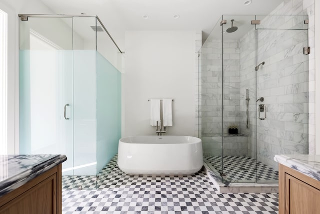 bathroom featuring a stall shower, a soaking tub, and vanity