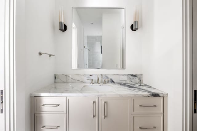 bathroom featuring walk in shower and vanity