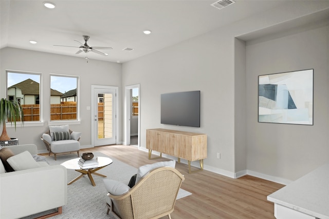 living room featuring ceiling fan and light hardwood / wood-style floors