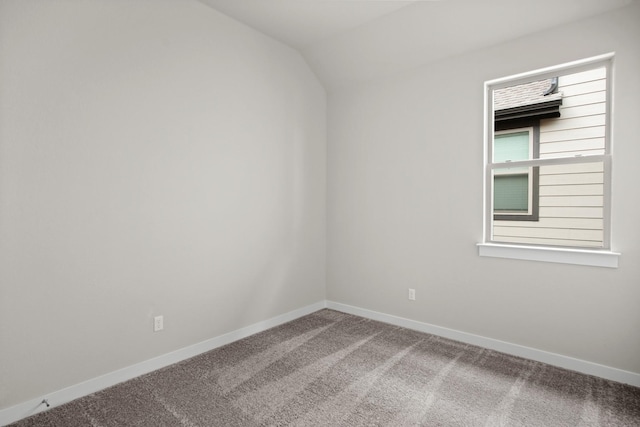 carpeted spare room with lofted ceiling