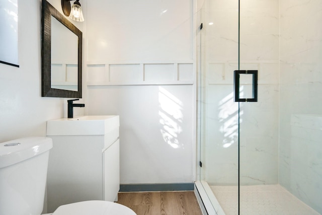 bathroom featuring walk in shower, vanity, toilet, and hardwood / wood-style flooring