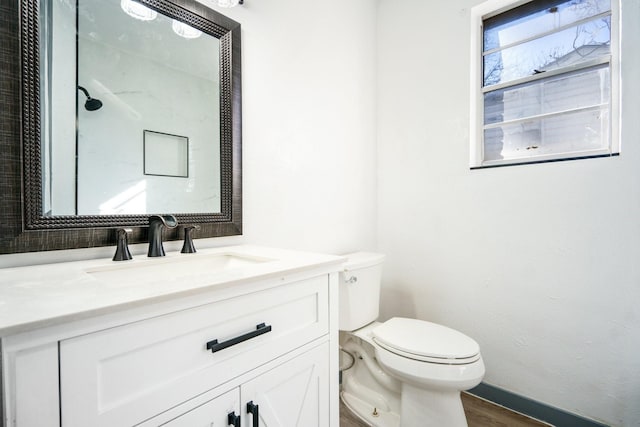 bathroom featuring vanity, wood-type flooring, and toilet