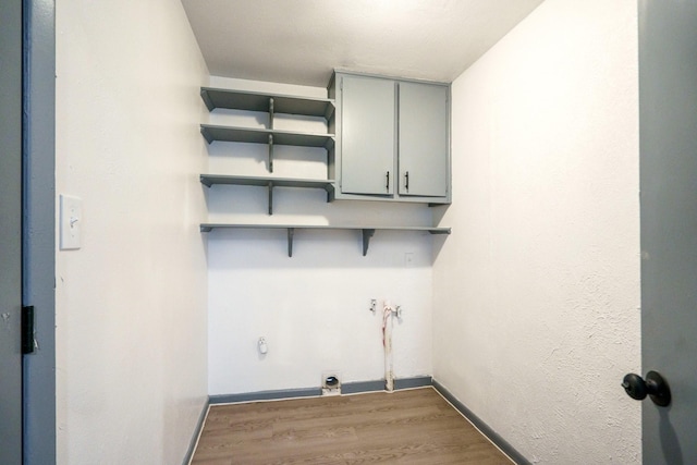 washroom featuring cabinets, hardwood / wood-style floors, and electric dryer hookup