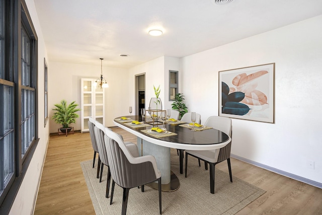 dining room with a chandelier and light hardwood / wood-style flooring