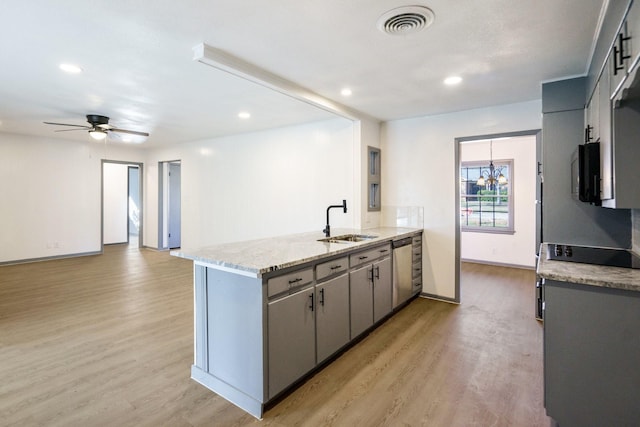 kitchen with sink, light hardwood / wood-style flooring, appliances with stainless steel finishes, gray cabinets, and light stone countertops