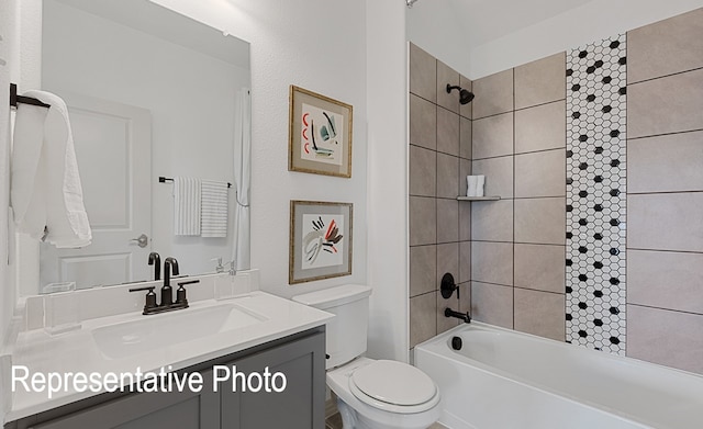 full bathroom with tiled shower / bath, vanity, and toilet