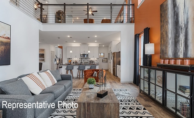 living room featuring a towering ceiling and wood-type flooring