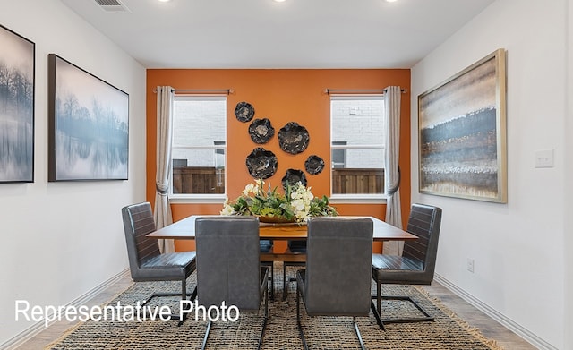 dining room featuring dark wood-type flooring and a healthy amount of sunlight