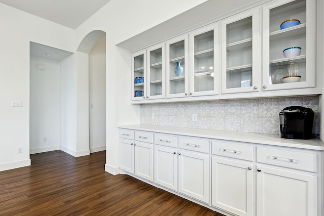 kitchen featuring backsplash, dark hardwood / wood-style floors, and white cabinets