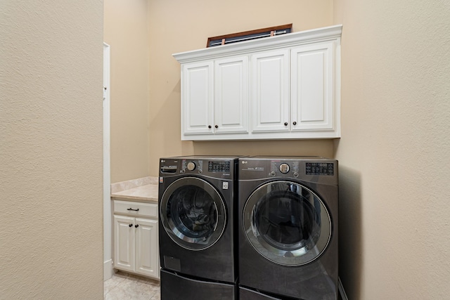 washroom featuring independent washer and dryer and cabinet space