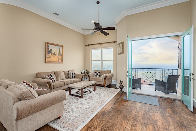 living area featuring dark wood-style flooring, visible vents, ornamental molding, ceiling fan, and baseboards