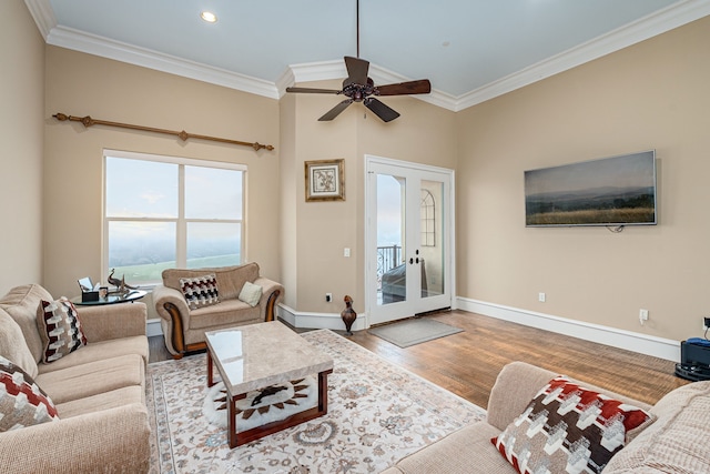 living area featuring baseboards, french doors, wood finished floors, and crown molding