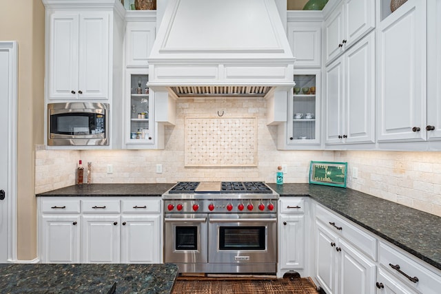 kitchen with stainless steel appliances, custom exhaust hood, and white cabinets