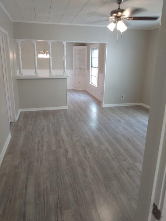 unfurnished living room with hardwood / wood-style floors, crown molding, and ceiling fan