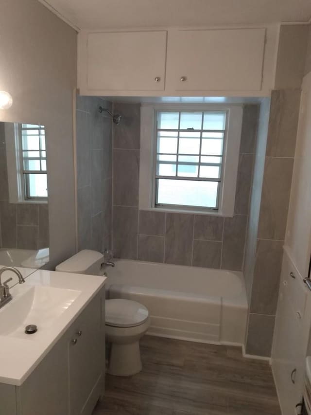 full bathroom with hardwood / wood-style flooring, vanity, a healthy amount of sunlight, and toilet