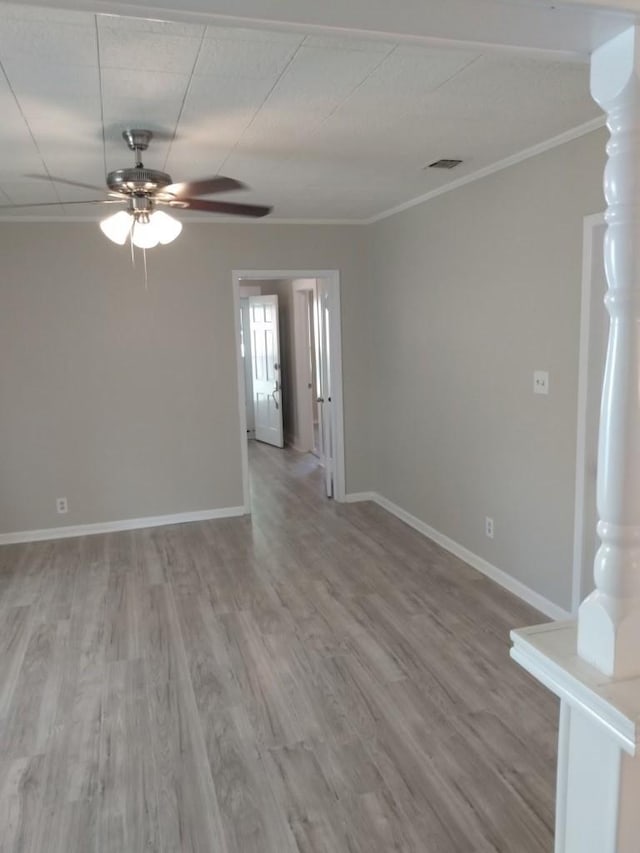 empty room featuring hardwood / wood-style flooring, crown molding, and ceiling fan