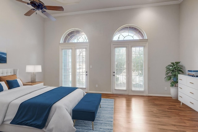 bedroom with multiple windows, crown molding, access to outside, and light wood-type flooring