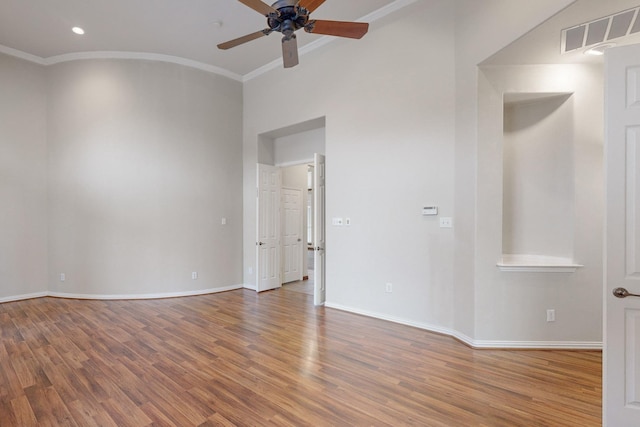 empty room with wood-type flooring, ornamental molding, and ceiling fan