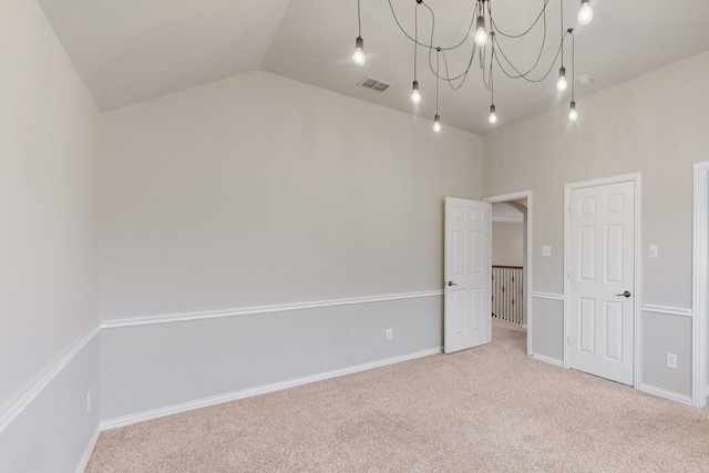 empty room featuring lofted ceiling and carpet