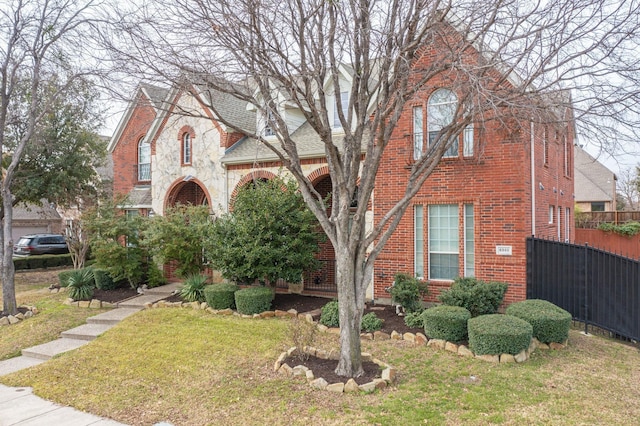 english style home featuring a front yard