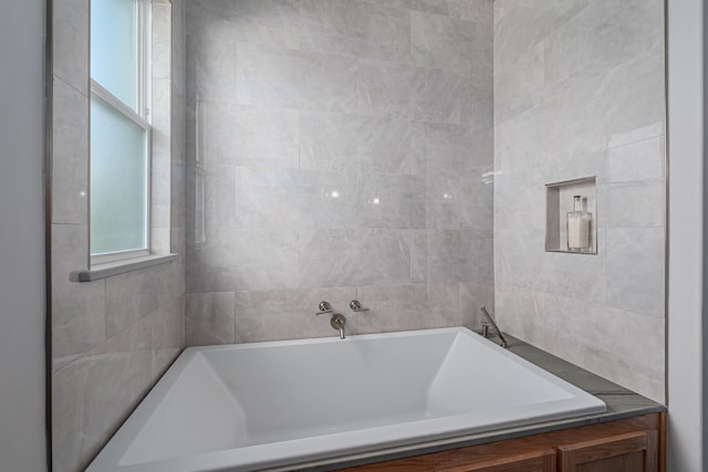 bathroom with a relaxing tiled tub and tile walls