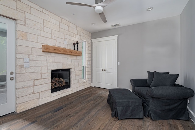 sitting room with a fireplace, dark hardwood / wood-style floors, and ceiling fan